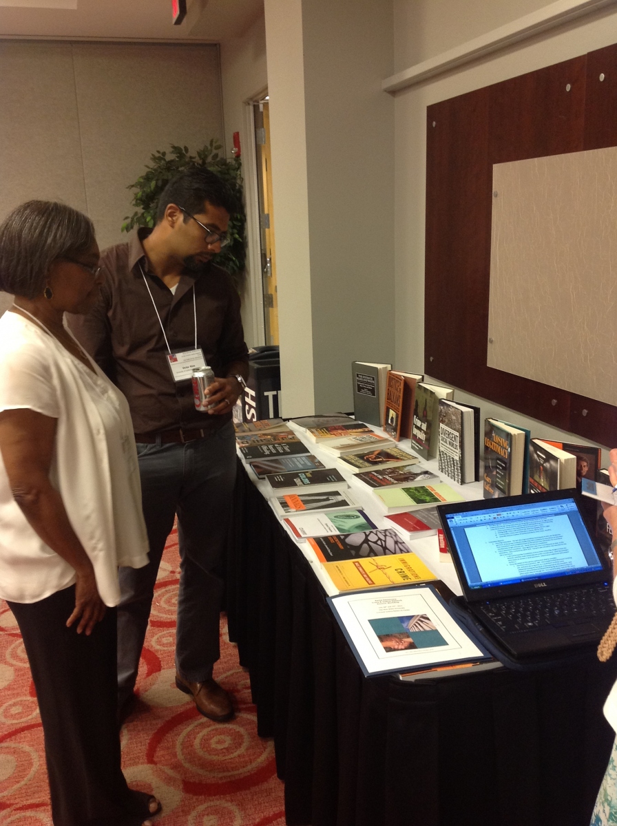 Ruth Peterson and Victor Rios perusing the book table 
